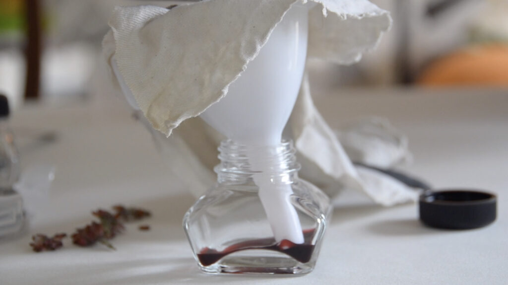 funnel in ink bottle straining berries to make ink