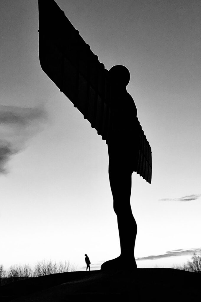 angel of the North with man looking up at it