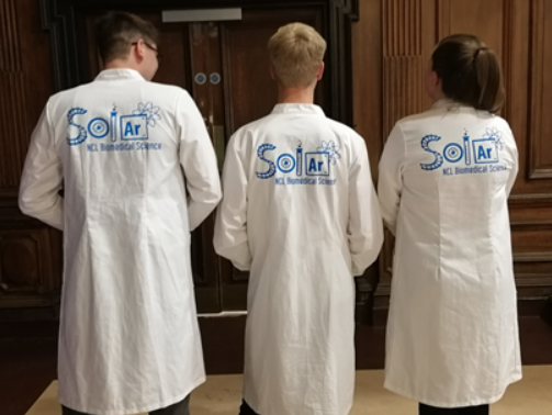 Science outreach volunteers wearing their custom SOLAR labcoats