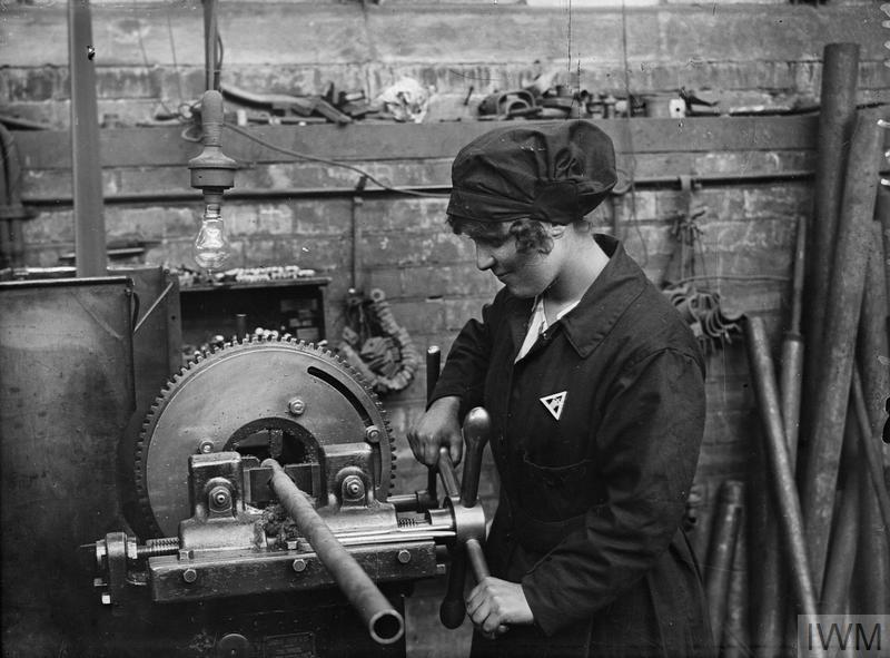 A woman worker operating a screwing machine at Sir W. G. Armstrong Whitworth and Company shipbuilding yard, Elswick, Newcastle (IWM, Q 20078).