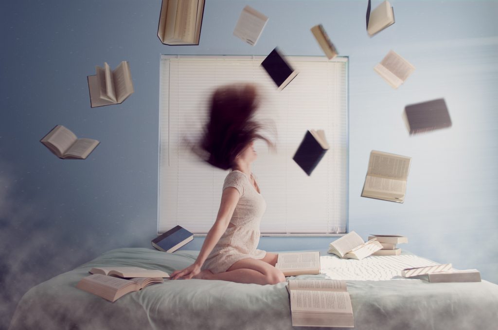 Woman throwing books up in the air