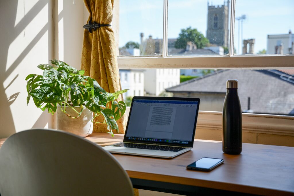 Laptop on a desk in front of a window