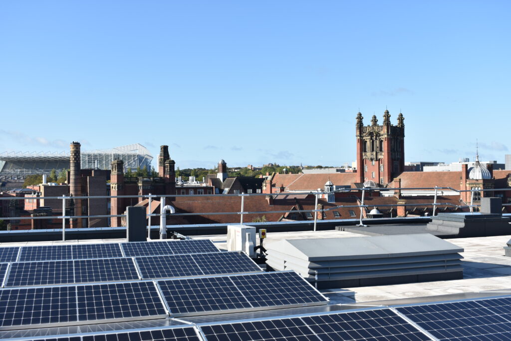Image: Solar panels on top of the Henry Daysh Building with other University buildings, including the Bedson and Armstrong Buildings, as well as St James’s Park, visible in the background. Credit: Charlotte Robson.
